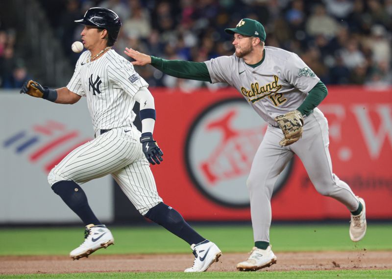 Apr 25, 2024; Bronx, New York, USA; Oakland Athletics third baseman Max Schuemann (12) throws the ball to second base forcing out New York Yankees third baseman Oswaldo Cabrera (95) at Yankee Stadium. Mandatory Credit: Vincent Carchietta-USA TODAY Sports