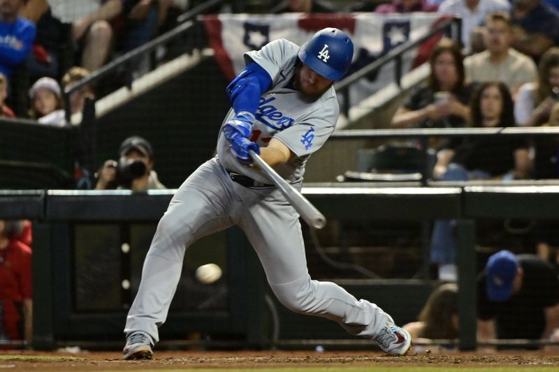 Oct 11, 2023; Phoenix, Arizona, USA; Los Angeles Dodgers third baseman Max Muncy (13) hits a single against the Arizona Diamondbacks in the seventh inning for game three of the NLDS for the 2023 MLB playoffs at Chase Field. Mandatory Credit: Matt Kartozian-USA TODAY Sports