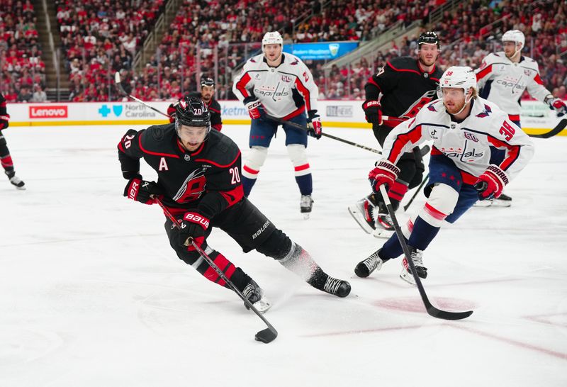 May 12, 2025; Raleigh, North Carolina, USA; Carolina Hurricanes center Sebastian Aho (20) skates with the puck against Washington Capitals defenseman Rasmus Sandin (38) during the first period in game four of the second round of the 2025 Stanley Cup Playoffs at Lenovo Center. Mandatory Credit: James Guillory-Imagn Images