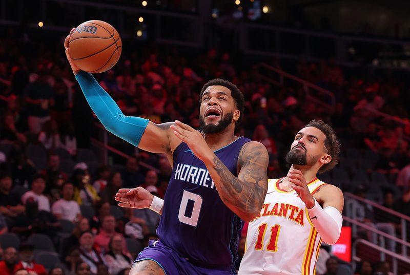 ATLANTA, GEORGIA - OCTOBER 25:  Miles Bridges #0 of the Charlotte Hornets draws a foul from Trae Young #11 of the Atlanta Hawks during the second quarter at State Farm Arena on October 25, 2024 in Atlanta, Georgia.  NOTE TO USER: User expressly acknowledges and agrees that, by downloading and/or using this photograph, user is consenting to the terms and conditions of the Getty Images License Agreement.  (Photo by Kevin C. Cox/Getty Images)