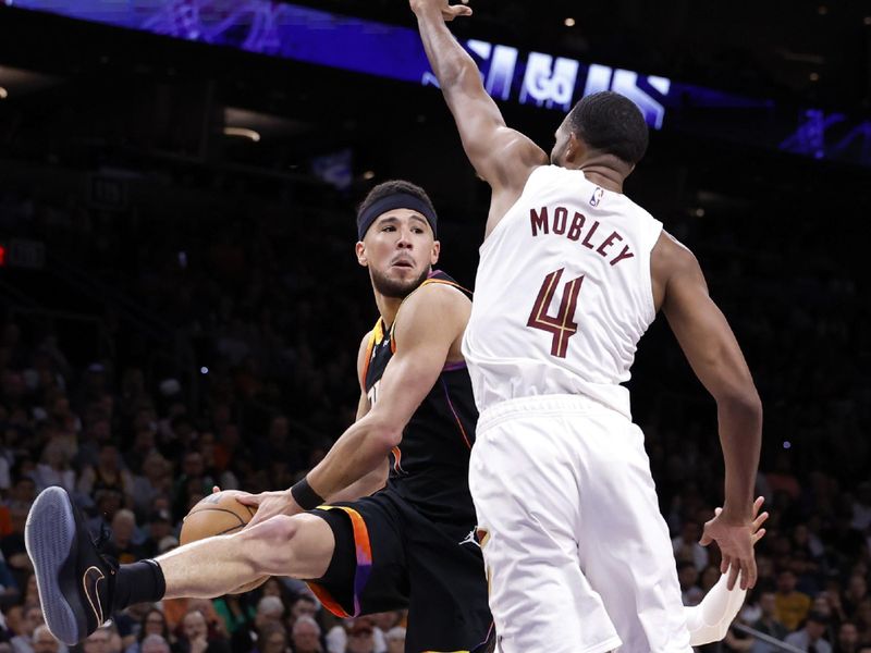 PHOENIX, ARIZONA - APRIL 03: Devin Booker #1 of the Phoenix Suns looks for a pass against Evan Mobley #4 of the Cleveland Cavaliers during the second half at Footprint Center on April 03, 2024 in Phoenix, Arizona. NOTE TO USER: User expressly acknowledges and agrees that, by downloading and or using this photograph, User is consenting to the terms and conditions of the Getty Images License Agreement.  (Photo by Chris Coduto/Getty Images)