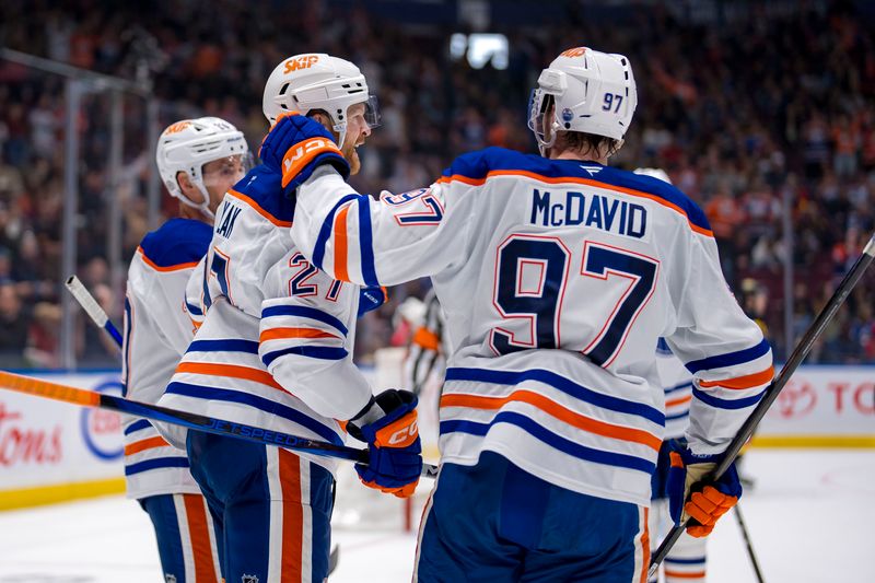 Nov 9, 2024; Vancouver, British Columbia, CAN; Edmonton Oilers defenseman Brett Kulak (27) anbd forward Connor McDavid (97) celebrate Kulak’s goal against the Vancouver Canucks during the third period at Rogers Arena. Mandatory Credit: Bob Frid-Imagn Images