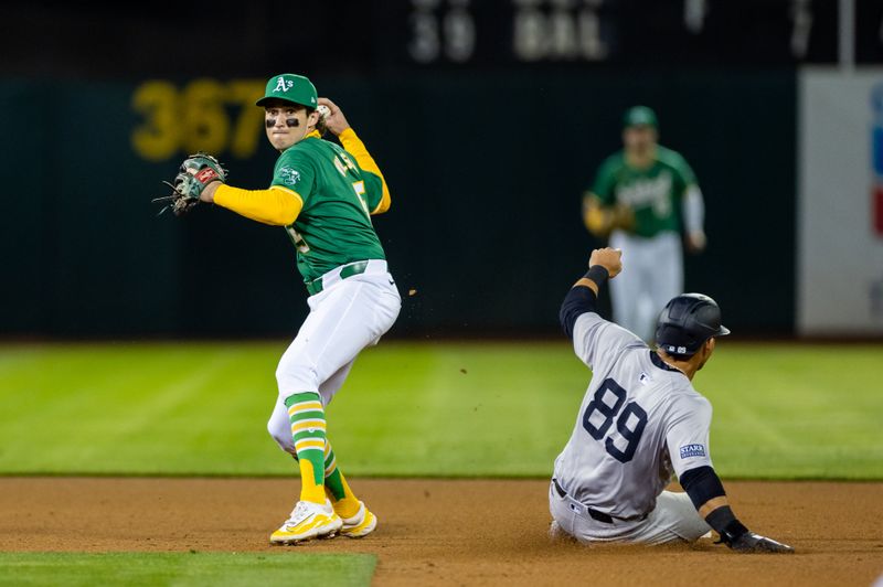 Sep 20, 2024; Oakland, California, USA; Oakland Athletics shortstop Jacob Wilson (5) turns a double play during the seventh inning against the New York Yankees at Oakland-Alameda County Coliseum. Mandatory Credit: Bob Kupbens-Imagn Images