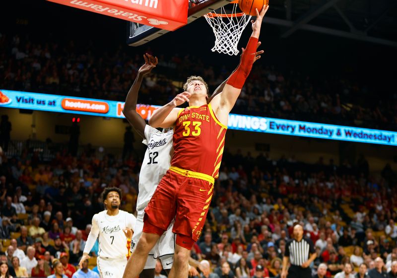 Feb 11, 2025; Orlando, Florida, USA;  Iowa State Cyclones center Brandton Chatfield (33) takes a shot as Central Florida Knights center Moustapha Thiam (52) defends at Addition Financial Arena. Mandatory Credit: Russell Lansford-Imagn Images
