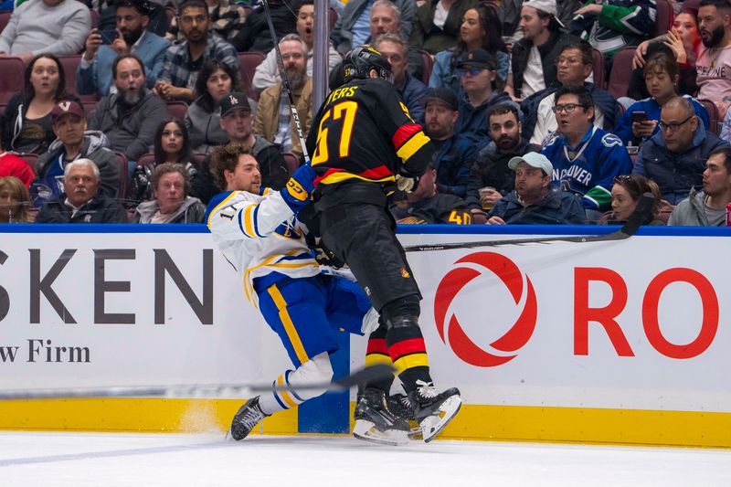 Mar 19, 2024; Vancouver, British Columbia, CAN; Vancouver Canucks defenseman Tyler Myers (57) checks Buffalo Sabres forward Tyson Jost (17) in the second period at Rogers Arena. Mandatory Credit: Bob Frid-USA TODAY Sports