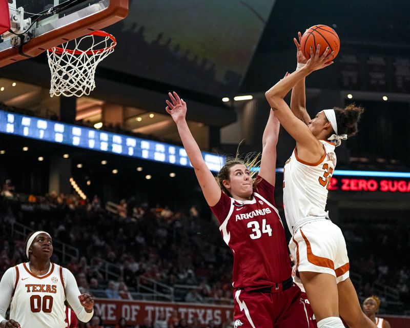 Jan 5, 2025; Austin, Texas, USA; Texas longhorns guard Ndjakalenga Mwenentanda (32) shoots the ball over Arkansas forward Jenna Lawrence (34) during the game at Moody Center. Mandatory Credit: Aaron E. Martinez/USA TODAY Network via Imagn Images