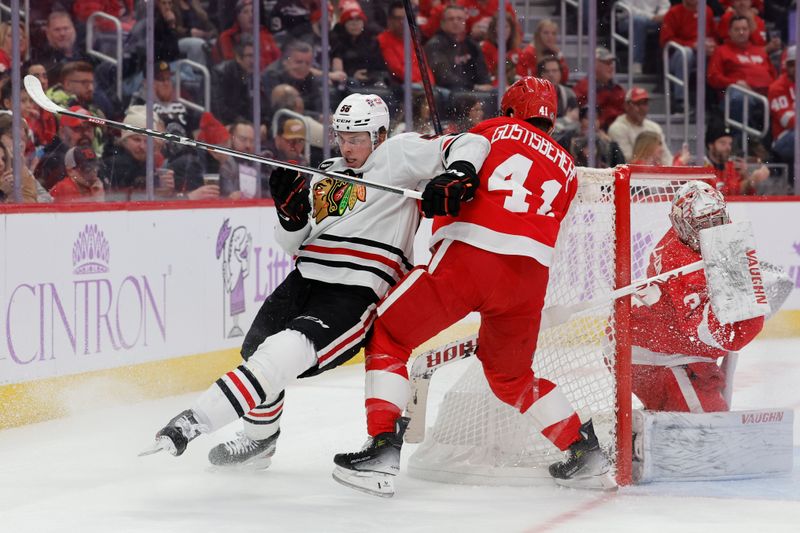 Nov 30, 2023; Detroit, Michigan, USA;  Chicago Blackhawks right wing MacKenzie Entwistle (58) and Detroit Red Wings defenseman Shayne Gostisbehere (41) battle for the puck in the first period at Little Caesars Arena. Mandatory Credit: Rick Osentoski-USA TODAY Sports