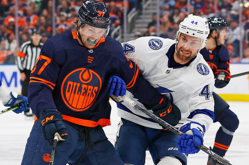 Dec 14, 2023; Edmonton, Alberta, CAN; Edmonton Oilers forward Warren Foegele (37) and Tampa Bay Lightning defensemen Calvin de Haan (44) battle for a loose puck during the third period at Rogers Place. Mandatory Credit: Perry Nelson-USA TODAY Sports