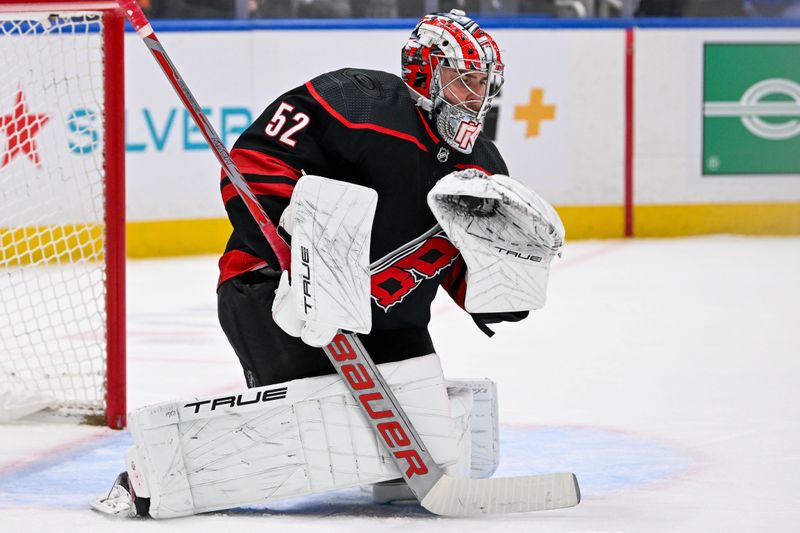 Mar 19, 2024; Elmont, New York, USA; Carolina Hurricanes goaltender Pyotr Kochetkov (52) makes a glove save against the New York Islanders during the second period at UBS Arena. Mandatory Credit: Dennis Schneidler-USA TODAY Sports