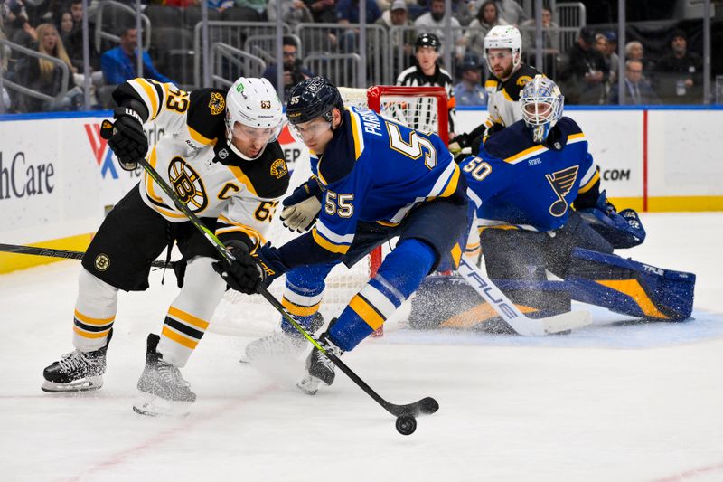 Nov 12, 2024; St. Louis, Missouri, USA;  Boston Bruins left wing Brad Marchand (63) controls the puck as St. Louis Blues defenseman Colton Parayko (55) and goaltender Jordan Binnington (50) defend the net during the first period at Enterprise Center. Mandatory Credit: Jeff Curry-Imagn Images