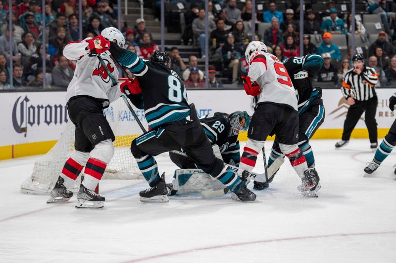 Feb 27, 2024; San Jose, California, USA;  San Jose Sharks goaltender Mackenzie Blackwood (29) makes a save as San Jose Sharks defenseman Jan Rutta (84) and New Jersey Devils defenseman Brendan Smith (2) battle for position in front of the net during the first period at SAP Center at San Jose. Mandatory Credit: Neville E. Guard-USA TODAY Sports