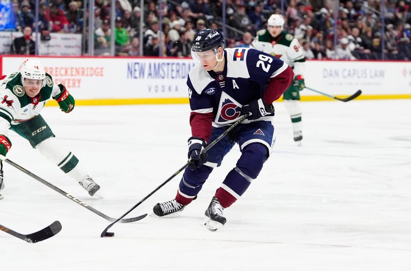 Jan 20, 2025; Denver, Colorado, USA; Colorado Avalanche center Nathan MacKinnon (29) controls the puck in the second period against the Minnesota Wild at Ball Arena. Mandatory Credit: Ron Chenoy-Imagn Images