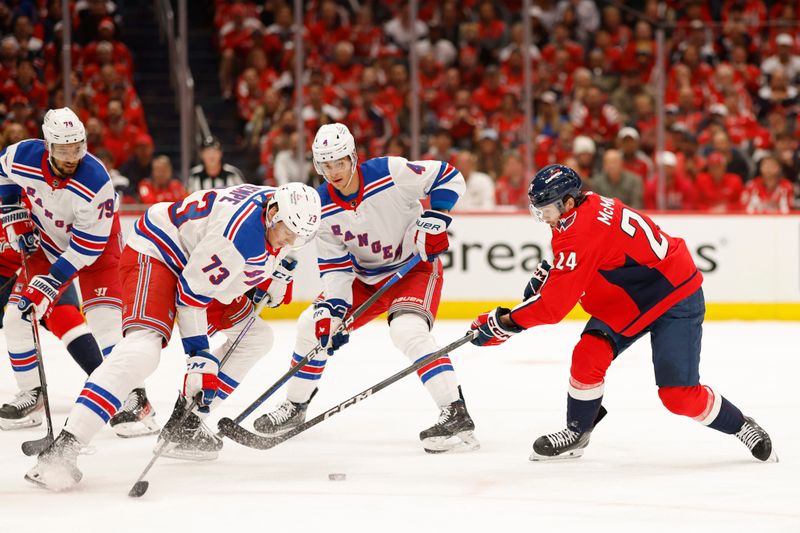 Apr 26, 2024; Washington, District of Columbia, USA; New York Rangers center Matt Rempe (73) and Washington Capitals center Connor McMichael (24) battle for the puck in the first period in game three of the first round of the 2024 Stanley Cup Playoffs at Capital One Arena. Mandatory Credit: Geoff Burke-USA TODAY Sports