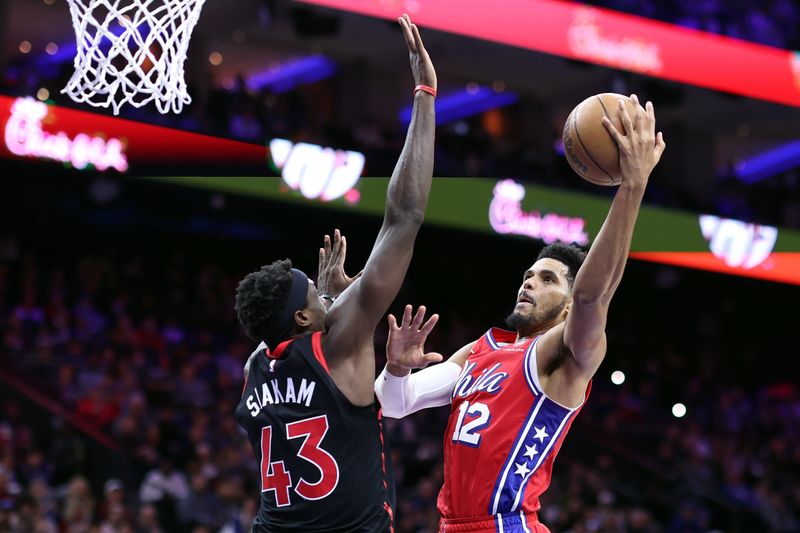 PHILADELPHIA, PENNSYLVANIA - DECEMBER 22: Tobias Harris #12 of the Philadelphia 76ers attempts a lay up past Pascal Siakam #43 of the Toronto Raptors during the third quarter at the Wells Fargo Center on December 22, 2023 in Philadelphia, Pennsylvania. NOTE TO USER: User expressly acknowledges and agrees that, by downloading and or using this photograph, User is consenting to the terms and conditions of the Getty Images License Agreement. (Photo by Tim Nwachukwu/Getty Images)