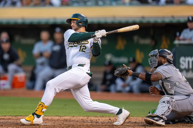 Aug 5, 2024; Oakland, California, USA;  Oakland Athletics shortstop Max Schuemann (12) hits a two run RBI single against the Chicago White Sox during the fourth inning at Oakland-Alameda County Coliseum. Mandatory Credit: Neville E. Guard-USA TODAY Sports