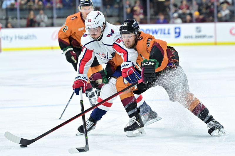 Jan 19, 2023; Tempe, Arizona, USA; Washington Capitals left wing Marcus Johansson (90) and Arizona Coyotes right wing Christian Fischer (36) battle for the puck in the first period at Mullett Arena. Mandatory Credit: Matt Kartozian-USA TODAY Sports