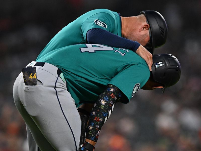 Aug 14, 2024; Detroit, Michigan, USA;  Seattle Mariners third base coach Manny Acta (14) checks on designated hitter Julio Rodríguez (44) after he injured himself during his at bat against the Detroit Tigers in the eighth inning at Comerica Park. Mandatory Credit: Lon Horwedel-USA TODAY Sports