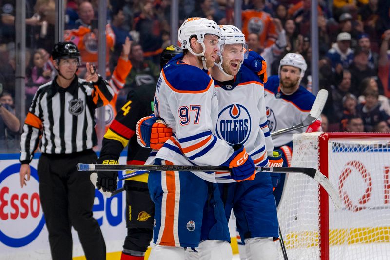 Nov 9, 2024; Vancouver, British Columbia, CAN; Edmonton Oilers forward Connor McDavid (97) celebrates with forward Zach Hyman (18) after scoring a goal against the Vancouver Canucks during the third period at Rogers Arena. Mandatory Credit: Bob Frid-Imagn Images