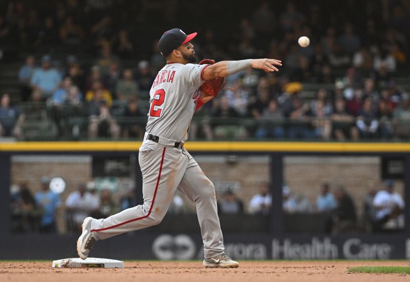 Sep 17, 2023; Milwaukee, Wisconsin, USA; Washington Nationals second baseman Luis Garcia (2) turns the double play against the Milwaukee Brewers in the fifth inning at American Family Field. Mandatory Credit: Michael McLoone-USA TODAY Sports