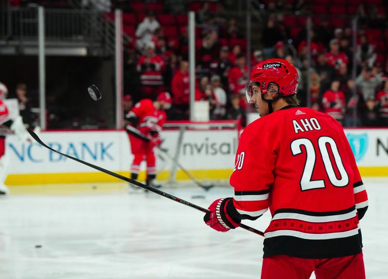 Dec 23, 2023; Raleigh, North Carolina, USA; Carolina Hurricanes center Sebastian Aho (20) bounces the puck on his stick before the game against the New York Islanders at PNC Arena. Mandatory Credit: James Guillory-USA TODAY Sports