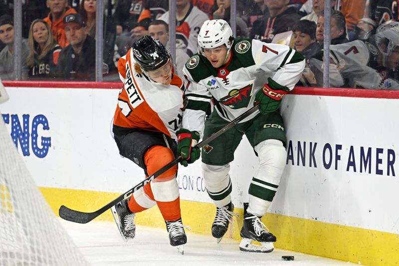 Oct 18, 2025; Philadelphia, Pennsylvania, USA; Minnesota Wild defenseman Brock Faber (7) and Philadelphia Flyers right wing Owen Tippett (74) battle for the puck during the first period at Wells Fargo Center. Mandatory Credit: Eric Hartline-Imagn Images