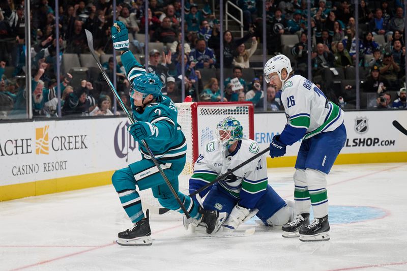 Nov 2, 2024; San Jose, California, USA; San Jose Sharks center Nico Sturm (7) reacts after scoring a goal against Vancouver Canucks goaltender Kevin Lankinen (32) and defenseman Erik Brannstrom (26) during the second period at SAP Center at San Jose. Mandatory Credit: Robert Edwards-Imagn Images