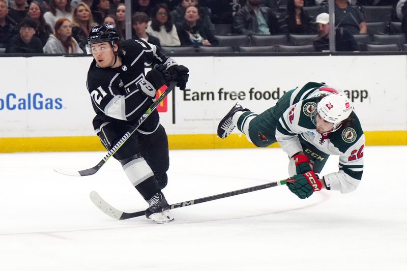 Apr 15, 2024; Los Angeles, California, USA; Minnesota Wild center Marat Khusnutdinov (22) shoots the puck against LA Kings defenseman Jordan Spence (21) in the third period at Crypto.com Arena. Mandatory Credit: Kirby Lee-USA TODAY Sports