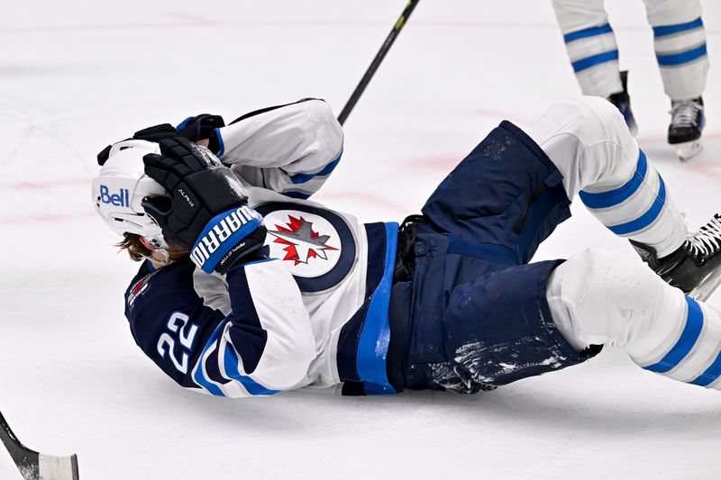 May 11, 2025; Dallas, Texas, USA; Winnipeg Jets center Mason Appleton (22) grabs his head after being hit by a puck during the first period against the Dallas Stars in game three of the second round of the 2025 Stanley Cup Playoffs at American Airlines Center. Mandatory Credit: Jerome Miron-Imagn Images
