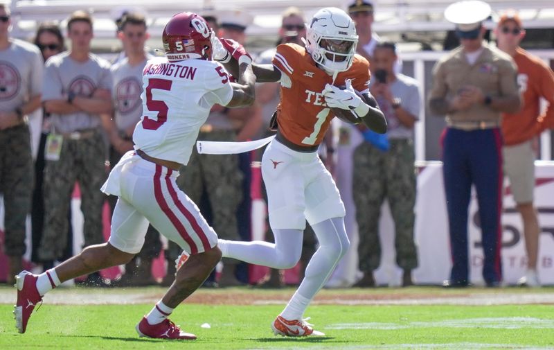 Oct 7, 2023; Dallas, Texas, USA; Texas Longhorns wide receiver Xavier Worthy (1) fights for yardage against Oklahoma Sooners defensive back Woodi Washington (5) in the first quarter at the Cotton Bowl. This game makes up the 119th rivalry match up. Mandatory Credit: Ricardo B. Brazziell-USA TODAY Sports