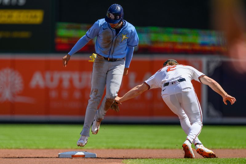 Sep 8, 2024; Baltimore, Maryland, USA; Tampa Bay Rays second baseman Christopher Morel (24) is tagged out stealing second base by Baltimore Orioles shortstop Gunnar Henderson (2) during the first inning at Oriole Park at Camden Yards. Mandatory Credit: Reggie Hildred-Imagn Images