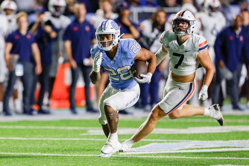 Oct 21, 2023; Chapel Hill, North Carolina, USA; North Carolina Tar Heels running back Omarion Hampton (28) runs for a first down ahead of Virginia Cavaliers linebacker James Jackson (7) in the second half at Kenan Memorial Stadium. Mandatory Credit: Nell Redmond-USA TODAY Sports