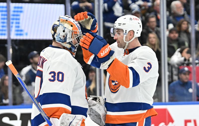 Feb 5, 2024; Toronto, Ontario, CAN;   New York Islanders goalie Ilya Sorokin (30) and defenseman Adam Pelech (3) celebrate after a win over the Toronto Maple Leafs at Scotiabank Arena. Mandatory Credit: Dan Hamilton-USA TODAY Sports