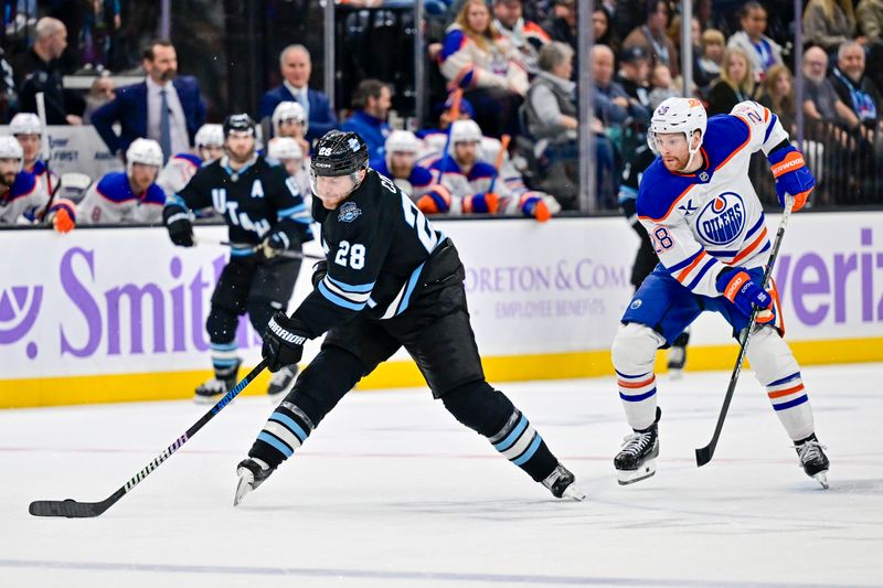 Nov 29, 2024; Salt Lake City, Utah, USA; Utah Hockey Club defenseman Ian Cole (28) passes around Edmonton Oilers right wing Connor Brown (28) during the third period at the Delta Center. Mandatory Credit: Christopher Creveling-Imagn Images