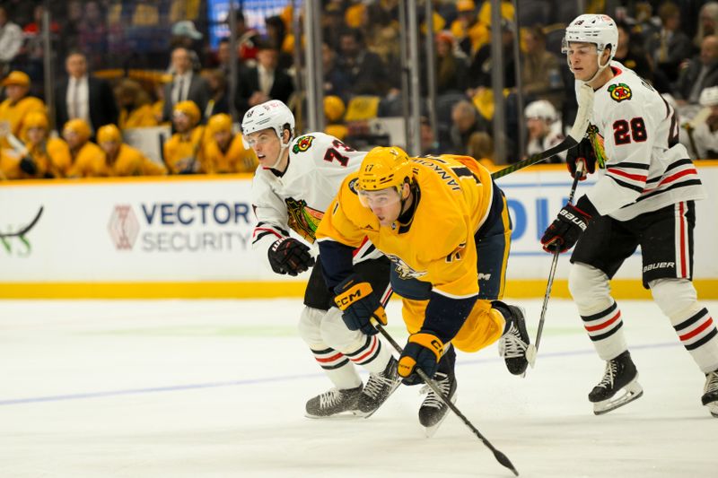 Jan 16, 2025; Nashville, Tennessee, USA;  Nashville Predators center Mark Jankowski (17) and Chicago Blackhawks left wing Lukas Reichel (73) battle for the puck during the first period at Bridgestone Arena. Mandatory Credit: Steve Roberts-Imagn Images