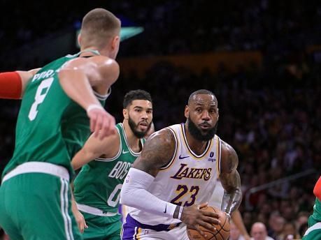 LOS ANGELES, CALIFORNIA - DECEMBER 25: LeBron James #23 of the Los Angeles Lakers is defended by Kristaps Porzingis #8 of the Boston Celtics at Crypto.com Arena on December 25, 2023 in Los Angeles, California. NOTE TO USER: User expressly acknowledges and agrees that, by downloading and or using this photograph, User is consenting to the terms and conditions of the Getty Images License Agreement.(Photo by Jayne Kamin-Oncea/Getty Images)