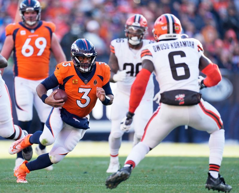 Denver Broncos quarterback Russell Wilson (3) runs as Cleveland Browns linebacker Jeremiah Owusu-Koramoah comes in for the stop in the first half of an NFL football game Sunday, Nov. 26, 2023, in Denver. (AP Photo/David Zalubowski)