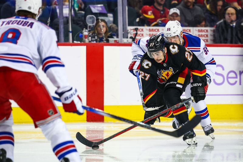 Nov 21, 2024; Calgary, Alberta, CAN; Calgary Flames right wing Matt Coronato (27) controls the puck against the New York Rangers during the second period at Scotiabank Saddledome. Mandatory Credit: Sergei Belski-Imagn Images