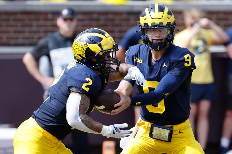 Sep 2, 2023; Ann Arbor, Michigan, USA; Michigan Wolverines quarterback J.J. McCarthy (9) hands off to running back Blake Corum (2) in the first half against the East Carolina Pirates at Michigan Stadium. Mandatory Credit: Rick Osentoski-USA TODAY Sports