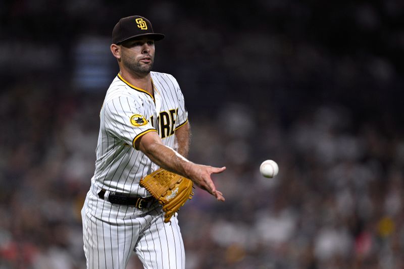 Aug 22, 2023; San Diego, California, USA; San Diego Padres relief pitcher Nick Martinez (21) tosses the ball to first base on a ground out by Miami Marlins catcher Nick Fortes (not pictured) during the eighth inning at Petco Park. Mandatory Credit: Orlando Ramirez-USA TODAY Sports