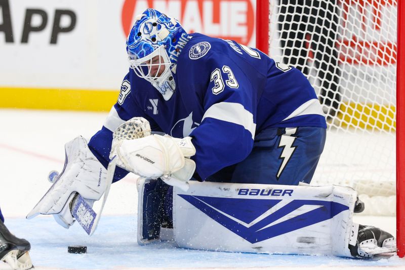 Oct 2, 2025; Tampa, Florida, USA; Tampa Bay Lightning goaltender Brandon Halverson (33) controls the puck against the Florida Panthers in the second period at Benchmark International Arena. Mandatory Credit: Nathan Ray Seebeck-Imagn Images