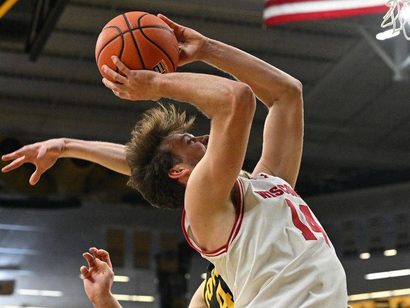 Feb 17, 2024; Iowa City, Iowa, USA; Wisconsin Badgers forward Carter Gilmore (14) goes to the basket as Iowa Hawkeyes guard Josh Dix (4) defends during the first half at Carver-Hawkeye Arena. Mandatory Credit: Jeffrey Becker-USA TODAY Sports