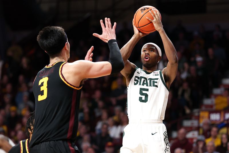 Feb 6, 2024; Minneapolis, Minnesota, USA; Michigan State Spartans guard Tre Holloman (5) shoots as Minnesota Golden Gophers forward Dawson Garcia (3) defends during the second half at Williams Arena. Mandatory Credit: Matt Krohn-USA TODAY Sports