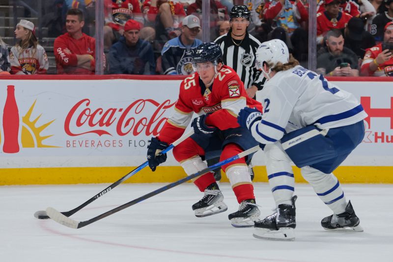 Nov 27, 2024; Sunrise, Florida, USA; Florida Panthers right wing Mackie Samoskevich (25) moves the puck against Toronto Maple Leafs defenseman Simon Benoit (2) during the first period at Amerant Bank Arena. Mandatory Credit: Sam Navarro-Imagn Images