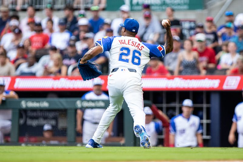 Jun 29, 2024; Cumberland, Georgia, USA; Atlanta Braves pitcher Raisel Iglesias (26) fields bunt for an out at first against the Pittsburgh Pirates during the eighth inning at Truist Park. Mandatory Credit: Jordan Godfree-USA TODAY Sports