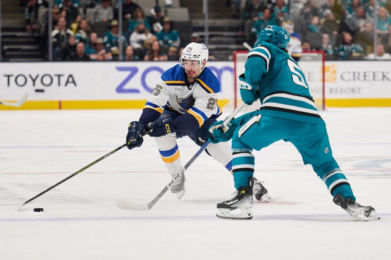 Apr 6, 2024; San Jose, California, USA; St. Louis Blues center Jordan Kyrou (25) plays the puck against San Jose Sharks right wing Collin Graf (51) during the first period at SAP Center at San Jose. Mandatory Credit: Robert Edwards-USA TODAY Sports