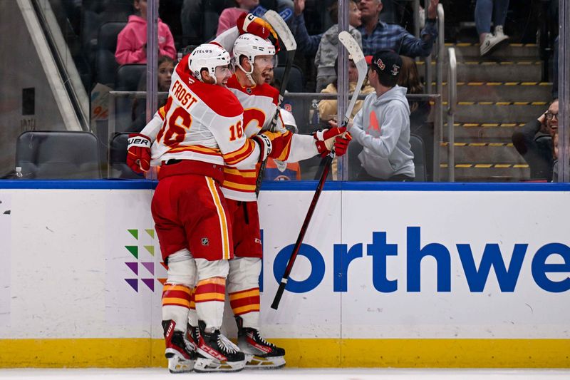 Mar 22, 2025; Elmont, New York, USA;  Calgary Flames left wing Jonathan Huberdeau (10) celebrates his game tying goal with Calgary Flames center Morgan Frost (16) against the New York Islanders during the third period at UBS Arena. Mandatory Credit: Dennis Schneidler-Imagn Images