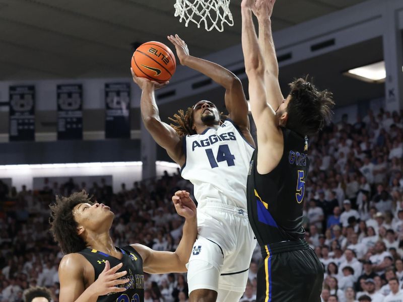 Jan 30, 2024; Logan, Utah, USA; Utah State Aggies guard Josh Uduje (14) goes to the basket against San Jose State Spartans forward Christian Wise (20) and forward Tibet Gorener (5) during the second half at Dee Glen Smith Spectrum. Mandatory Credit: Rob Gray-USA TODAY Sports