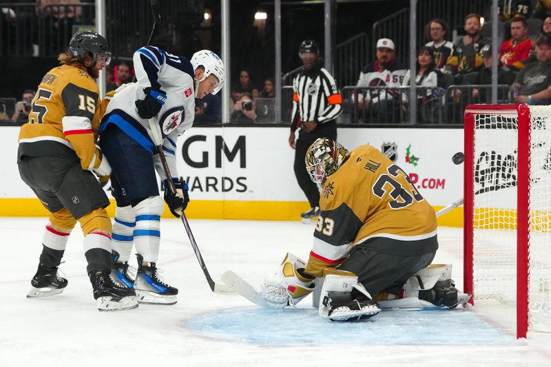 Nov 29, 2024; Las Vegas, Nevada, USA; Winnipeg Jets center Cole Perfetti (91) deflects the puck past Vegas Golden Knights goaltender Adin Hill (33) to score a goal during the first period at T-Mobile Arena. Mandatory Credit: Stephen R. Sylvanie-Imagn Images