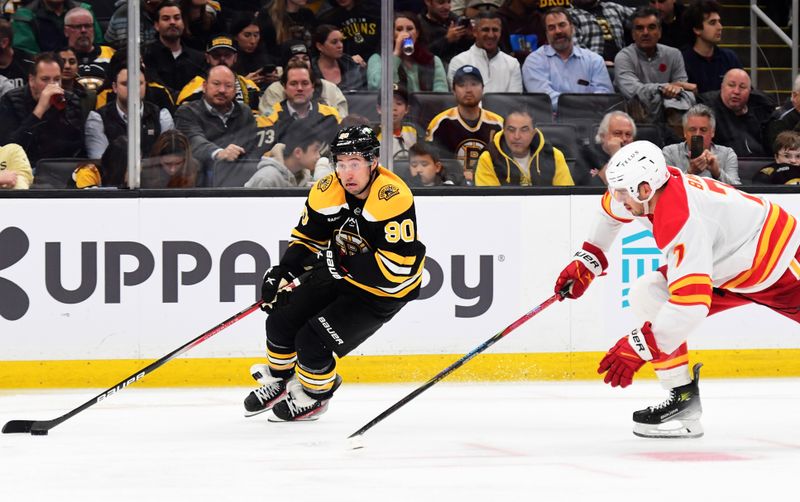 Nov 7, 2024; Boston, Massachusetts, USA;  Boston Bruins center Tyler Johnson (90) controls the puck while Calgary Flames defenseman Kevin Bahl (7) defends during the third period at TD Garden. Mandatory Credit: Bob DeChiara-Imagn Images