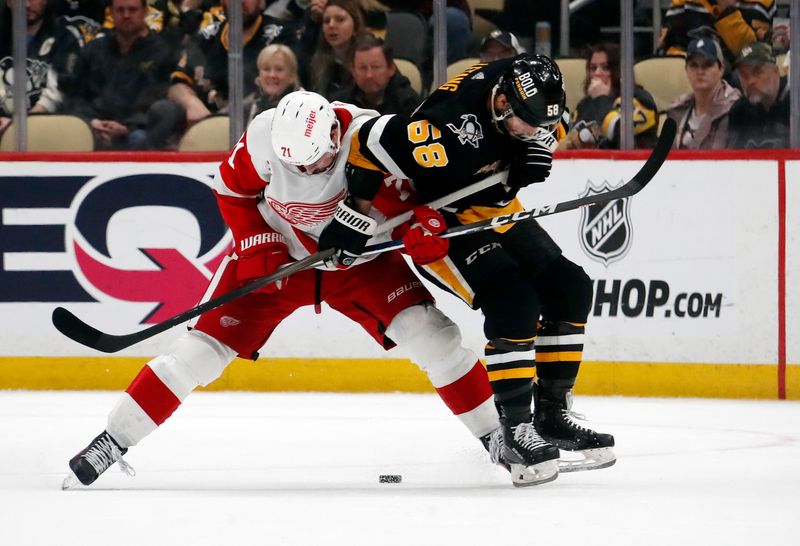 Apr 11, 2024; Pittsburgh, Pennsylvania, USA; Detroit Red Wings center Dylan Larkin (71) and Pittsburgh Penguins defenseman Kris Letang (58) battle for the puck in overtime at PPG Paints Arena. Pittsburgh won 6-5 in overtime. Mandatory Credit: Charles LeClaire-USA TODAY Sports